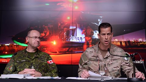 中将斯蒂芬·鲍斯(左)和准将彼得·达维在渥太华国防部记者招待会上发言。